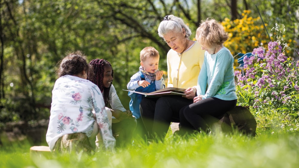 starsza kobieta czyta dzieciom z książki