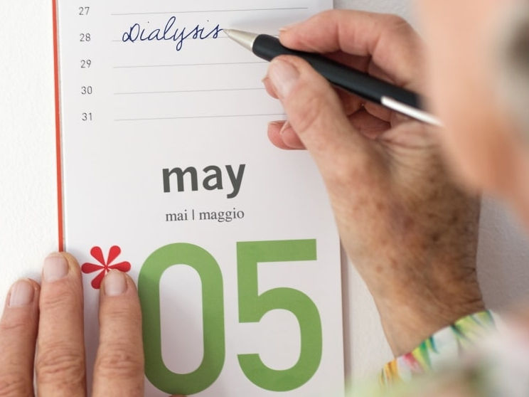 starsza kobieta robi notatki w kalendarzu