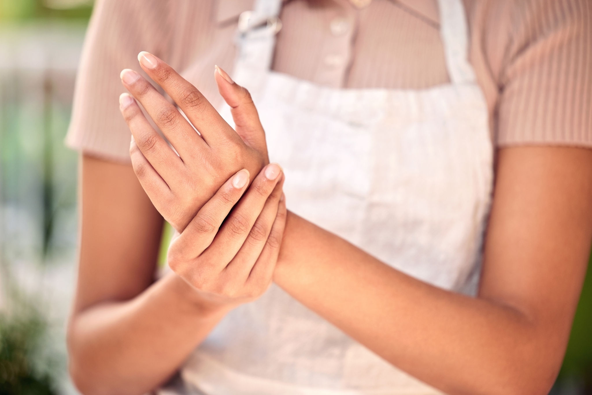 Wrist pain, woman hands and closeup for working in nursery, small business and gardening with problem. Girl, entrepreneur and arthritis in shop, store and joint injury with burnout in workplace.