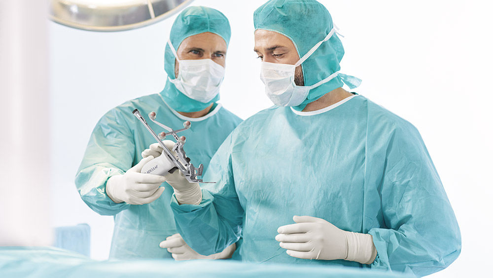 Dwóch chirurgów za pomocą narzędzia uniwersalnego OrthoPilot® Elite