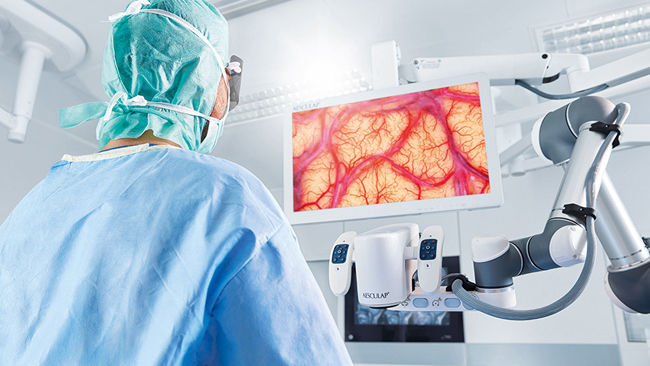 Chirurg na sali operacyjnej z cyfrową platformą mikroskopu chirurgicznego Aesculap Aeos®