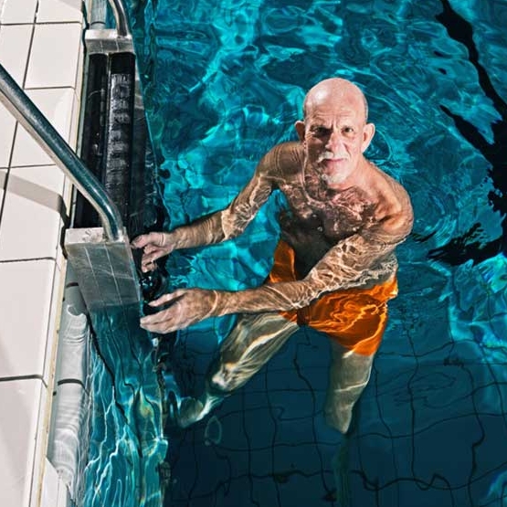 starszy mężczyzna na drabinie w basenie
