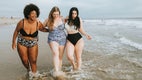 Trzy młode kobiety na plaży, stopy w wodzie: Lubię spędzać czas z przyjaciółmi na plaży.