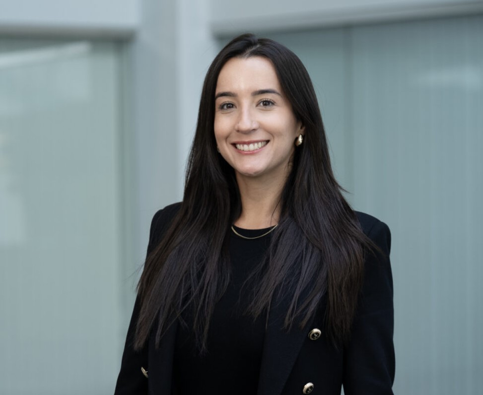 Woman in a black blazer standing in front of a modern building