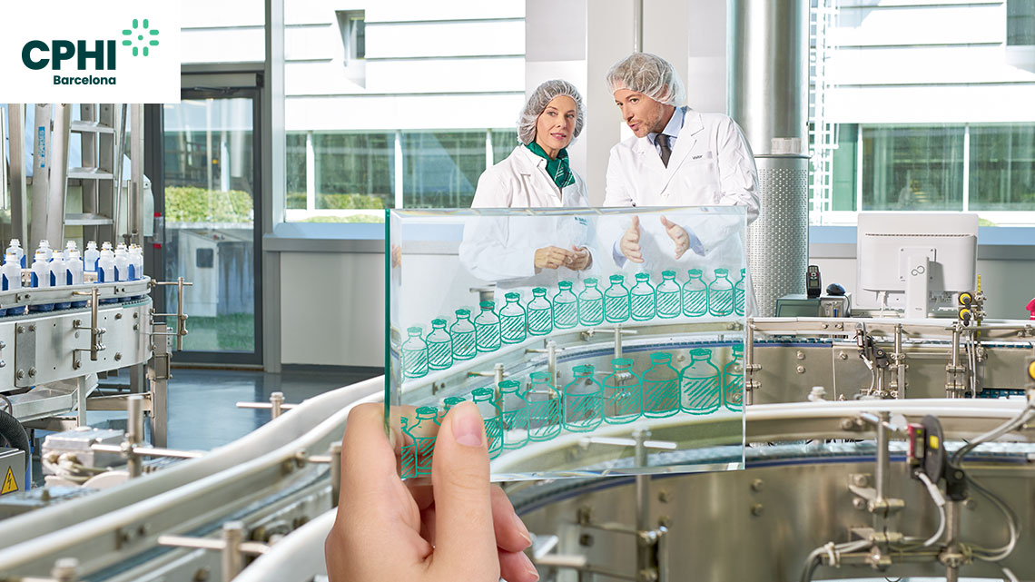 Dwóch pracowników produkcji w fartuchach laboratoryjnych rozmawia