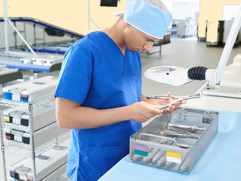 Pracownik opieki zdrowia sprawdzający instrumenty chirurgiczne w systemach kontenerów sterylizacyjnych