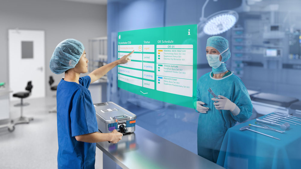 Kobieta pracująca w służbie zdrowia stojąca przed ogromnym ekranem z narzędziem do zarządzania zasobami chirurgicznymi